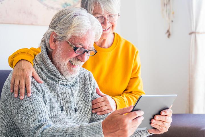 elderly couple looking at ipad